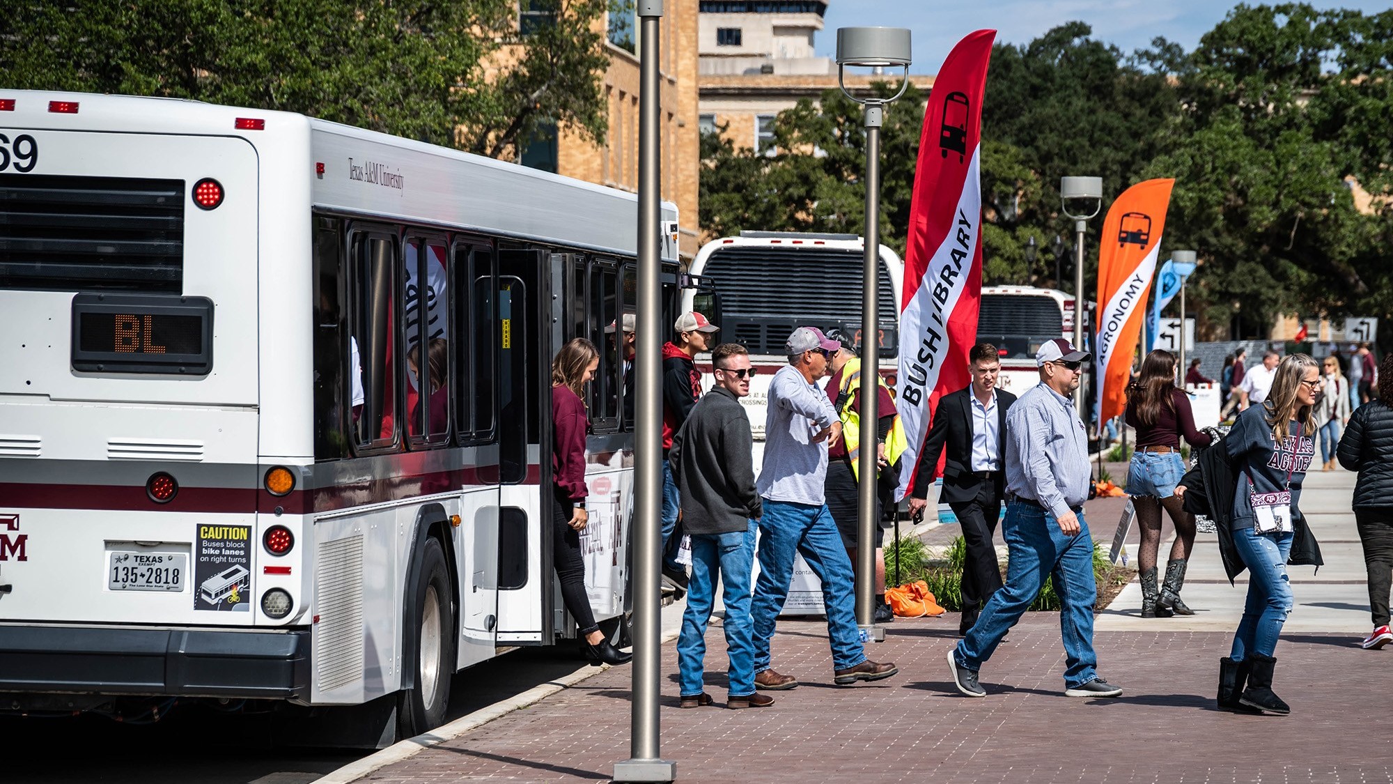 fans unload from bus on campus